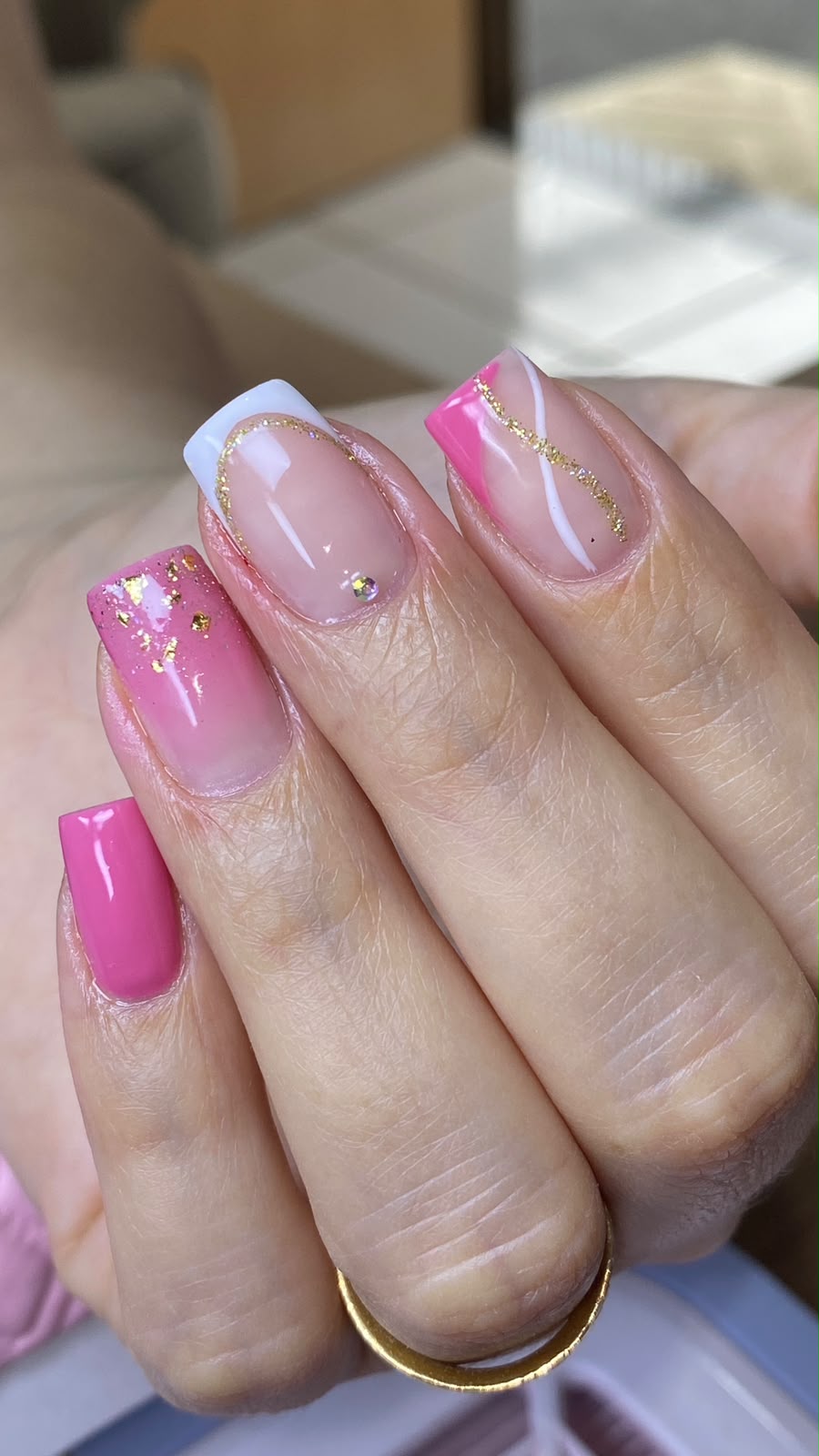 Unhas de gel em rosa e branco com detalhes dourados